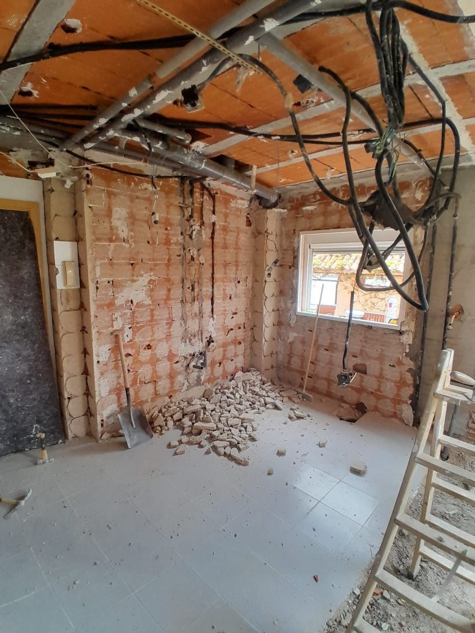 Cocina en demolición con cableado antiguo colgando